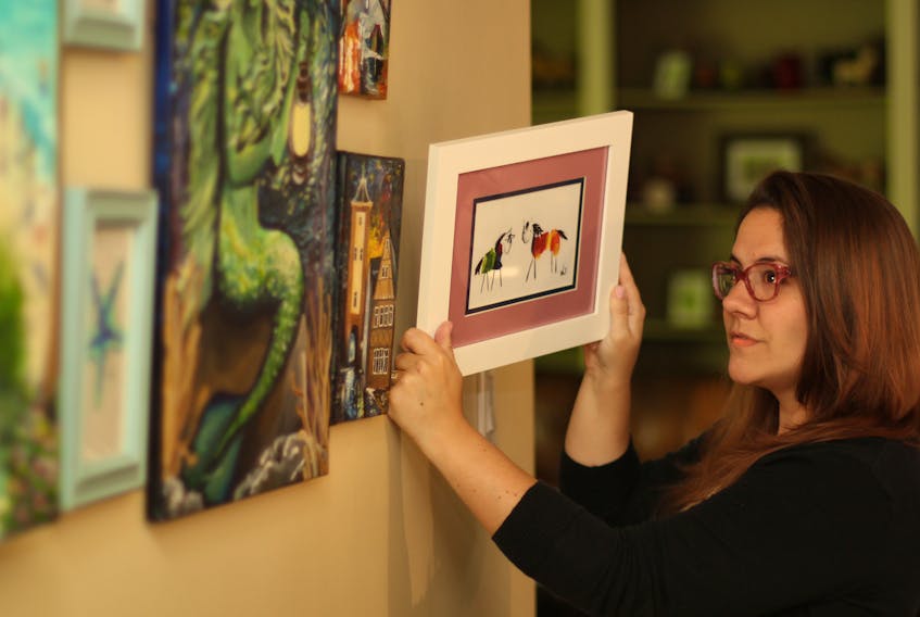 Artist Wendy Johnston hangs one of her original paintings, Rainbow Ponies, a work that has proven to be her most popular and had led to her opening a virtual shop. As of Friday, Johnston’s artwork can be viewed at the New Waterford Credit Union Art Gallery, where it will remain until Sept. 28.
