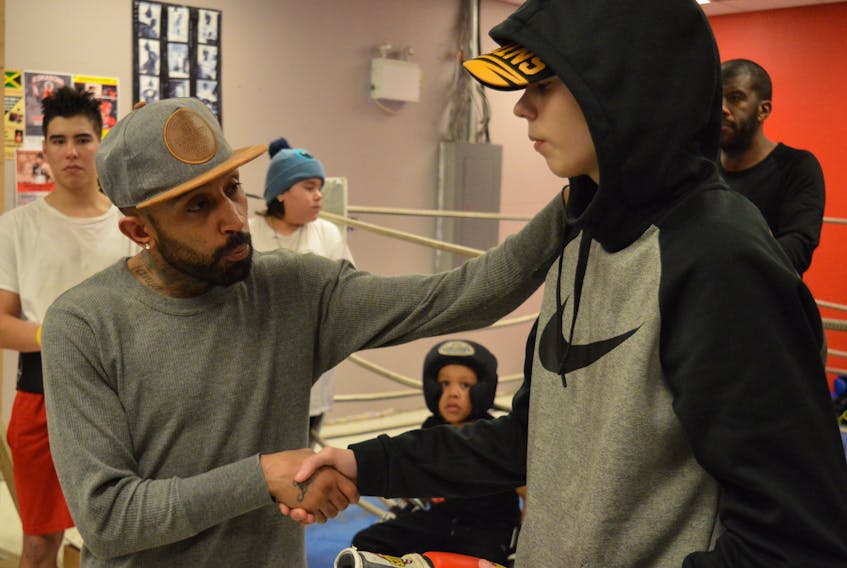 Professional boxer Tison Cave, left, shakes the hand of Ethan Marshall of Eskasoni after giving him a signed boxing glove at Red Tribe Boxing Club on Jan. 24. The Halifax boxer was in Eskasoni speaking with children following some recent unexpected deaths that have shaken the community.