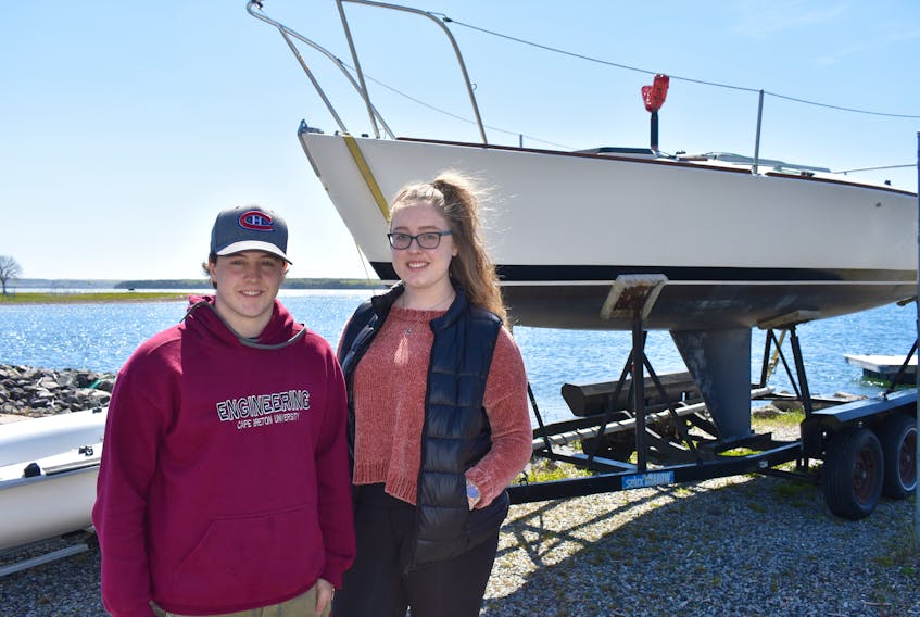 Jeff Devoe, left, and Georgina Hatcher stand near a boat at the Northern Yacht Club in North Sydney on Wednesday. The local yacht club will be launching a new adult learn to sail program, with three programs scheduled for June and July. The first session will begin on Monday.