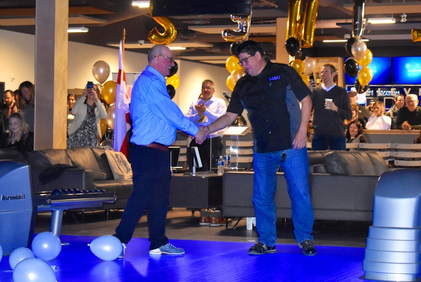 Chief Terry Paul, left, and bowling enthusiast Clifford Paul shake hands after throwing the first balls of Thursday’s official grand opening of the Lanes at Membertou, a $5.1 million state-of-the-art bowling facility that also includes a restaurant and bar, a number of sports simulation machines and a private function room.