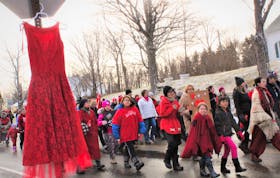 A red dress symbolizing missing and murdered Indigenous women hung from a stop sign as a solemn group of about 70 people walked toward Cassidy Bernard’s hometown of We’kmoa’q on Dec. 1. Bernard was found dead in her First Nation home on Oct. 24. RCMP continue to investigate her death.