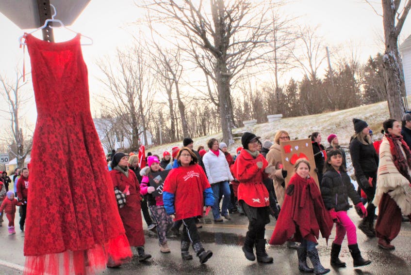 A red dress symbolizing missing and murdered Indigenous women hung from a stop sign as a solemn group of about 70 people walked toward Cassidy Bernard’s hometown of We’kmoa’q on Dec. 1. Bernard was found dead in her First Nation home on Oct. 24. RCMP continue to investigate her death.