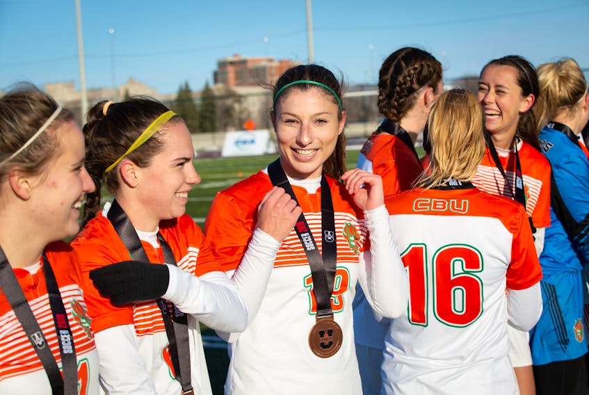 Defender Becky Hanna of Howie Centre, centre, is shown with her U Sports bronze medal after the Cape Breton Capers women defeated the McMaster Marauders 1-0 on Nov. 11 in Ottawa.