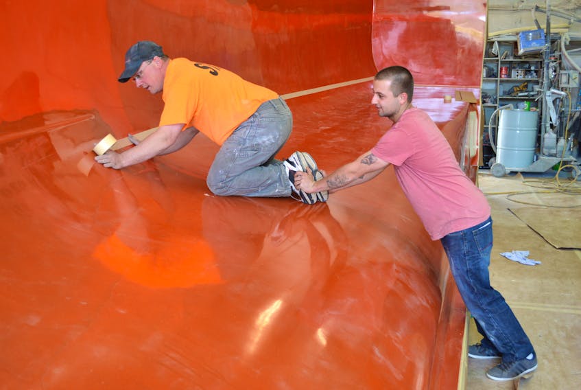 Mark Head, left, of Glace Bay, manager of Long Beach Boat Building in Port Morien, works on a hull mould for a new lobster boat being built for a client in New Brunswick, assisted by Matthew MacNeil of Tower Road. The Cape Breton Regional Municipality council approved an amendment to the land use bylaw which enables Head to purchase the former Gowrie school and open a boat building business.