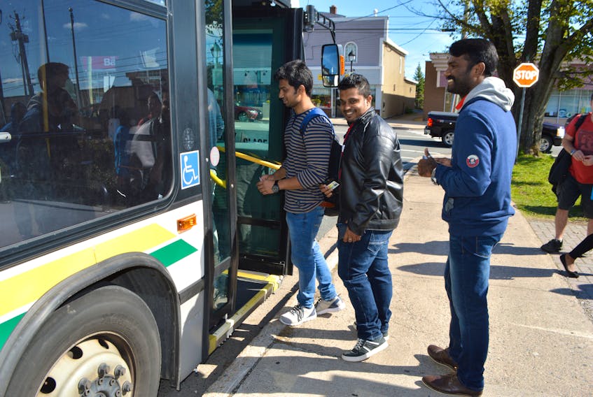 Cape Breton University students Sarin Spillai, from left, Ajay Kuruvilla Matthew and Aswin Pariyaran, all from India, get on a Transit Cape Breton bus in Glace Bay heading to CBU last September. The Cape Breton Regional Municipality formed a partnership with the university to offer more direct routes to CBU to alleviate a transportation problem faced by many university students, including its robust international student population.