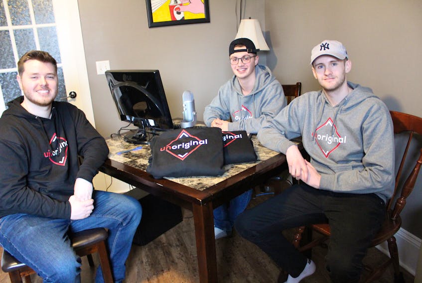 Cameron LaTulippe (left), Markus Mischiek (back right) and Stephen MacGillivary sit in their current office, a room in LaTulippe’s parents’ home, the “base of operations” for their Unoriginal Clothing Line and podcast. The three have been friend since grade two and started dreaming of going into business together since high school. These dreams have started to become a reality after they launch their casual clothing company on May 10, after roughly two years of planning and saving money for start-up costs.