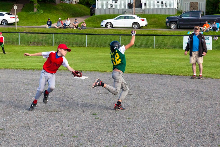 A Carter's Cresting Cubs baserunner avoids a tag from Y's Guys second baseman Connor MacDougall in Amherst Little League A system action at the Ernie Landry Memorial Field.