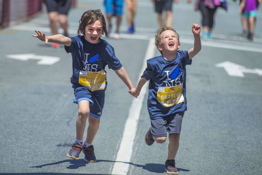 Elijah and Brayden celebrate crossing the finish line in the Doctors Nova Scotia four-kilometre run on Saturday. Thousands of kids tore through the streets of downtown Halifax in the annual run.