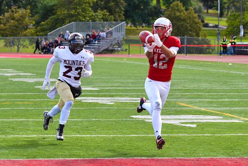 Acadia Axemen receiver Cordell Hastings catches the ball for a touchdown as Mount Allison Mounties defensive back Phillip Thompson tries to chase him down. Acadia and Mount A are tied for third place in the Atlantic football conference at 2-3 heading into this weekend.