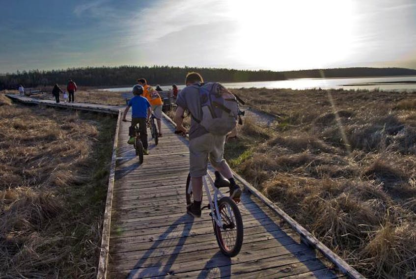 Youths cycle along the boardwalk at McCormacks Beach Provincial Park in Eastern Passage near the popular Fishman’s Cove retail area, which is starting to reawaken for another season.