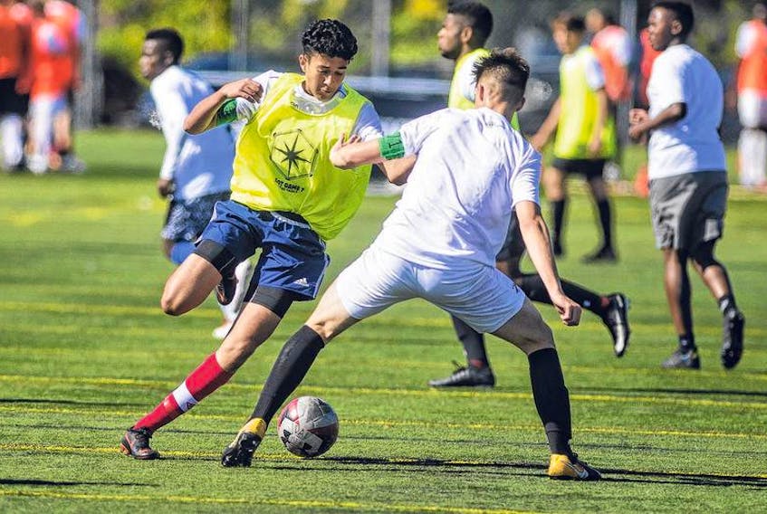 Sulimon Elomrani, left, tries to shake a defender at the Canadian Premier League open trials on Thursday morning. More than 100 soccer players are attending in an attempt to make a Canadian Premier League club roster.