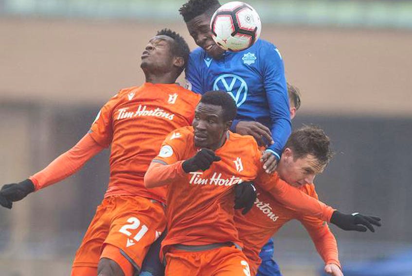 HFX Wanderers FC’s Andre Bona battles for the ball with a trio of Forge FC players during last Saturday’s home opener at the Wanderers Grounds.