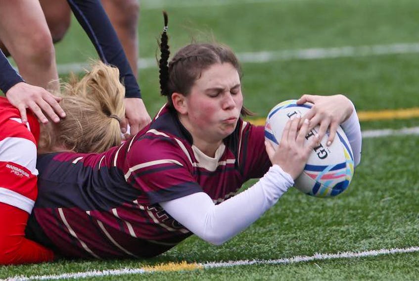 Citadel’s Kathleen Dolan is tackled as she scores a try against Halifax West during metro high school girls’ rugby action on Mainland Common on Thursday. The Phoenix defeated the Warriors 48-12.