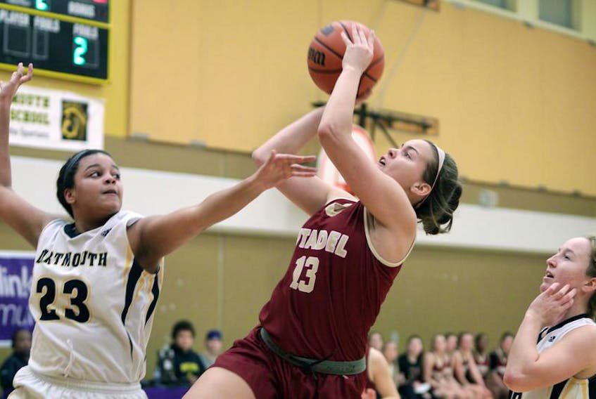 Mackenzie States of the Citadel Phoenix takes her shot while avoiding the defence from Dartmouth Spartans’ Chloe Wilson in metro high school girls’ basketball play Monday.