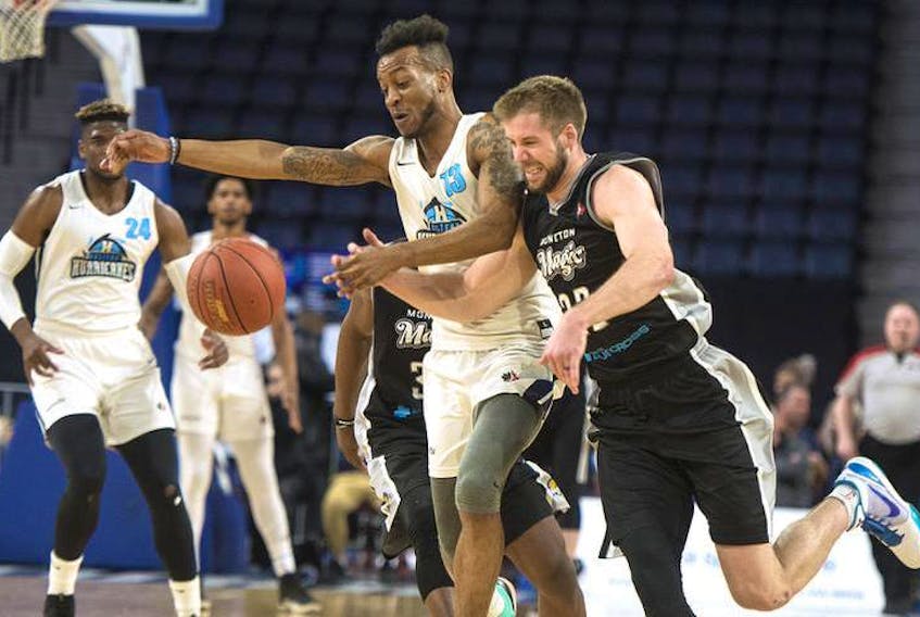 Halifax Hurricanes’ Joel Kindred, left, and Moncton Magic’s Wayne McCullough chase down a loose ball during the first half of Friday night’s NBL Canada playoff game at the Scotiabank Centre.