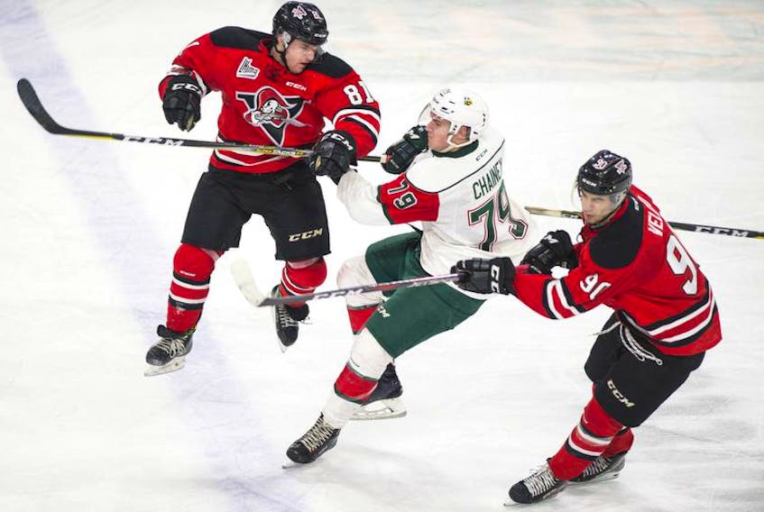 Drummondville Voltigeurs forward Xavier Simoneau leaves his feet to hit Halifax Mooseheads defenceman Jocktan Chainey, middle, during a QMJHL game at the Scotiabank Centre last season. The Mooseheads and Voltigeurs are projected to be the top two teams in the league this year.