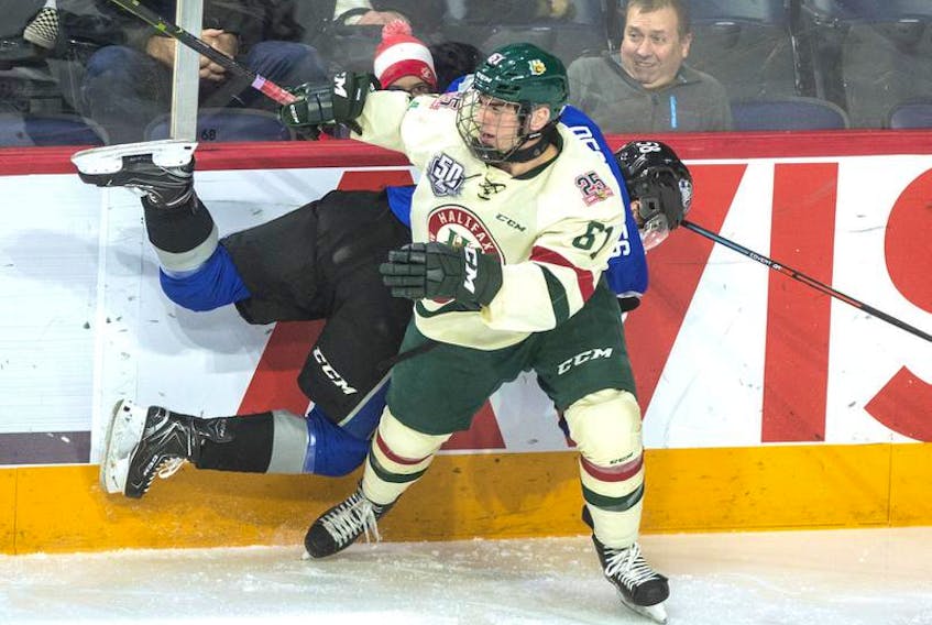 Halifax Mooseheads winger Joel Bishop pastes Saint John Sea Dogs defenceman Charlie DesRoches into the boards during the first period of Tuesday night’s QMJHL game at Scotiabank Centre.