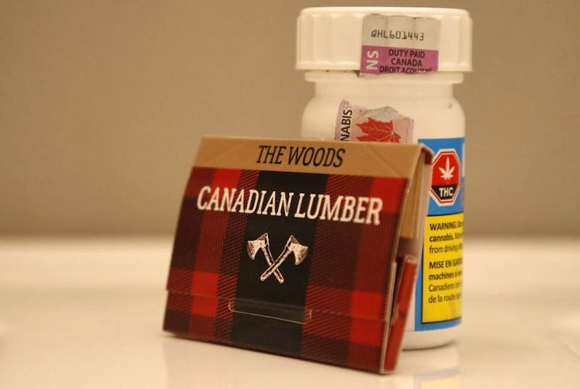 A package of Canadian Woods rolling papers rests on a bottle of cannabis.