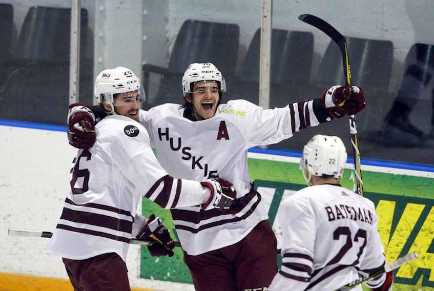 Saint Mary’s Huskies’ Anthony Repaci celebrates with his teammates Bronson Beaton, left, and Adam Bateman during an Atlantic university hockey game last February. SMU faces the St. Francis Xavier X-Men in the best-of-five conference semifinal, which begins Thursday at the Halifax Forum.