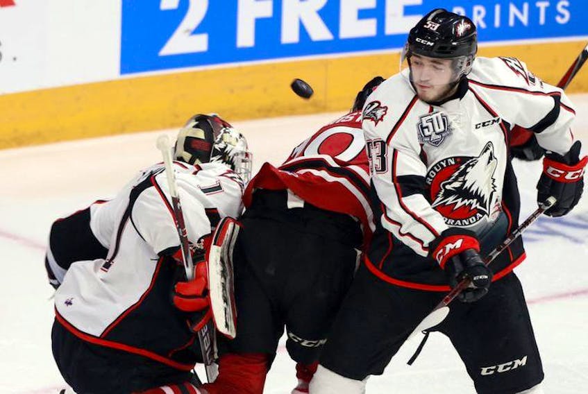 Rouyn-Noranda Huskies defenceman Noah Dobson and goalie Samuel Harvey track the flying puck during Saturday’s Memorial Cup game against the Guelph Storm at the Scotiabank Centre.