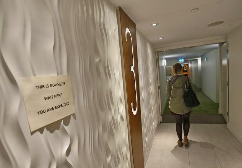 A spectator heads down a hallway in a Birmingham Street apartment suite before attending the Zuppa Theatre theatrical performance This is Nowhere.