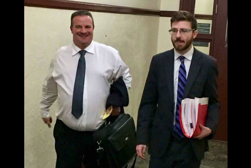 Barry Douglas Pincock, left, is all smiles Monday as he leaves Halifax provincial court with lawyer Brendan Martin after sentencing on two counts of fraud.