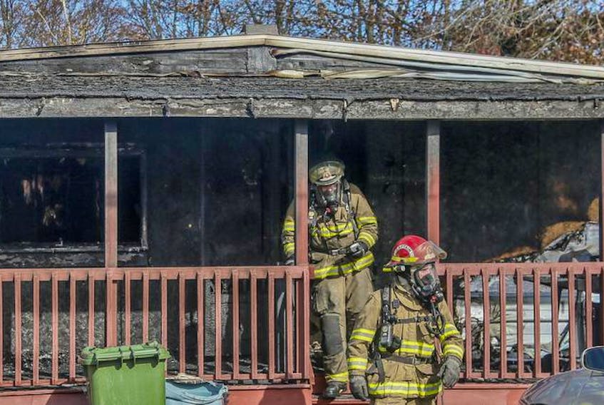 Halifax regional firefighers walk out of a heavily heavily damaged home in Middle Sackville on Oct. 24. Halifax Fire officials said there are too many buildings without working fire detectors.