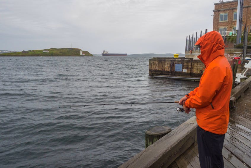 A man fishes on the Halifax waterfront despite the rain on August 19, 2017. We may be spared the aftermath of a hurricane, but that won't keep us dry.