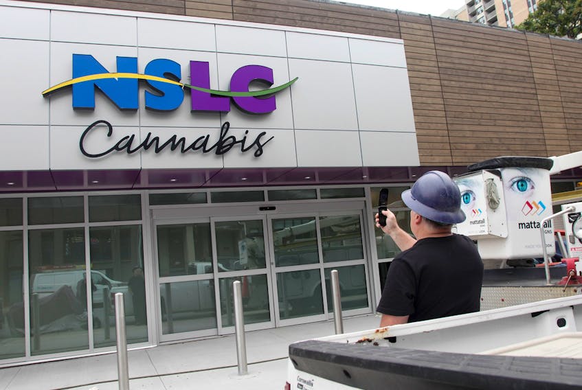 A contractor photographs the cannabis signage he just helped install at the soon-to-be opened NSLC Cannabis outlet on Clyde Street in Halifax Monday.