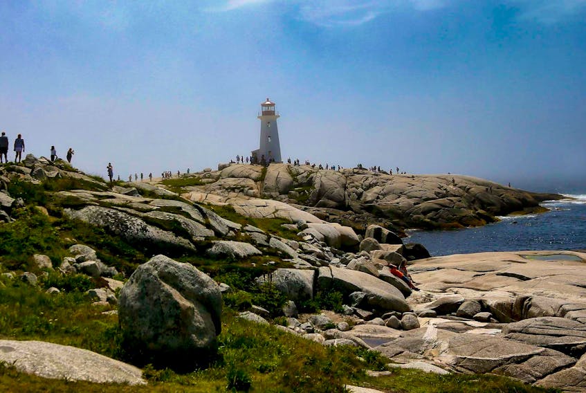 Tourists walk towards the lighthouse at Peggy’s Cove, N.S., on Wednesday, July 25, 2018.