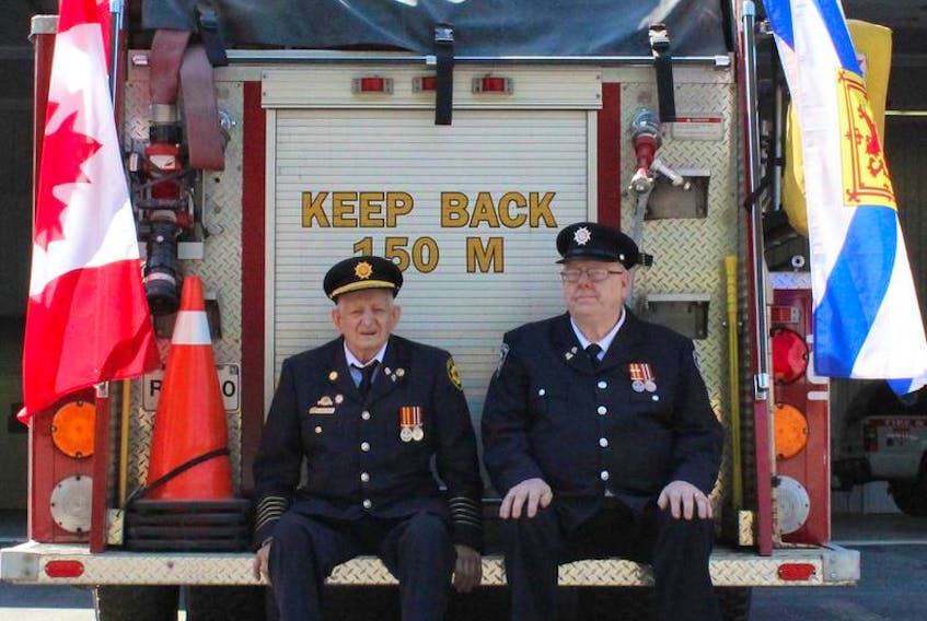 North Queens Fire Association members Thomas Cushing, left, and Douglas Wolfe were recently honoured for 65 years of service to their department.