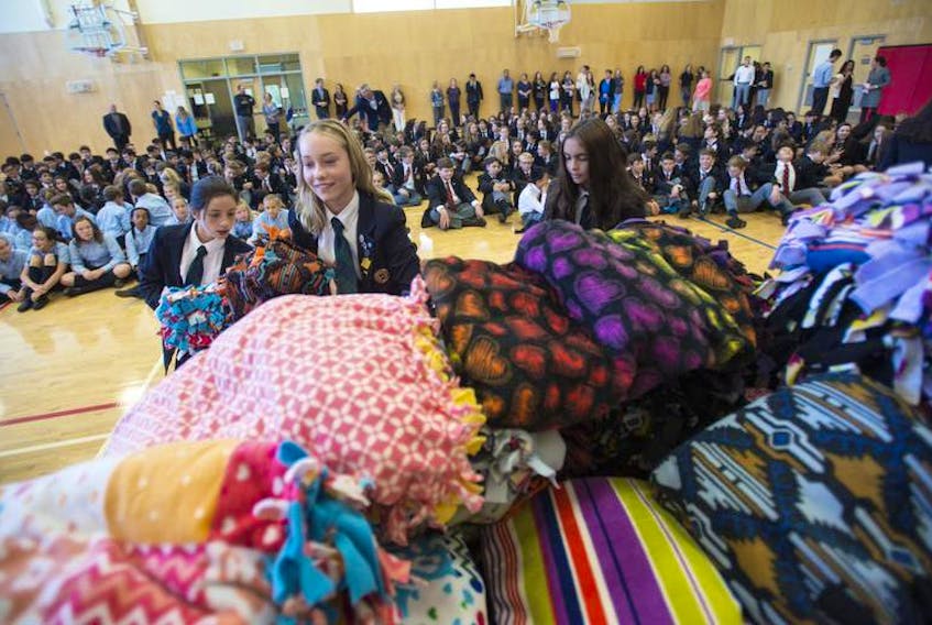 Sacred Heart students Camilla, Emma and Paulina add to the pile of blankets they and their schoolmates made for an initiative called 3 Wishes.