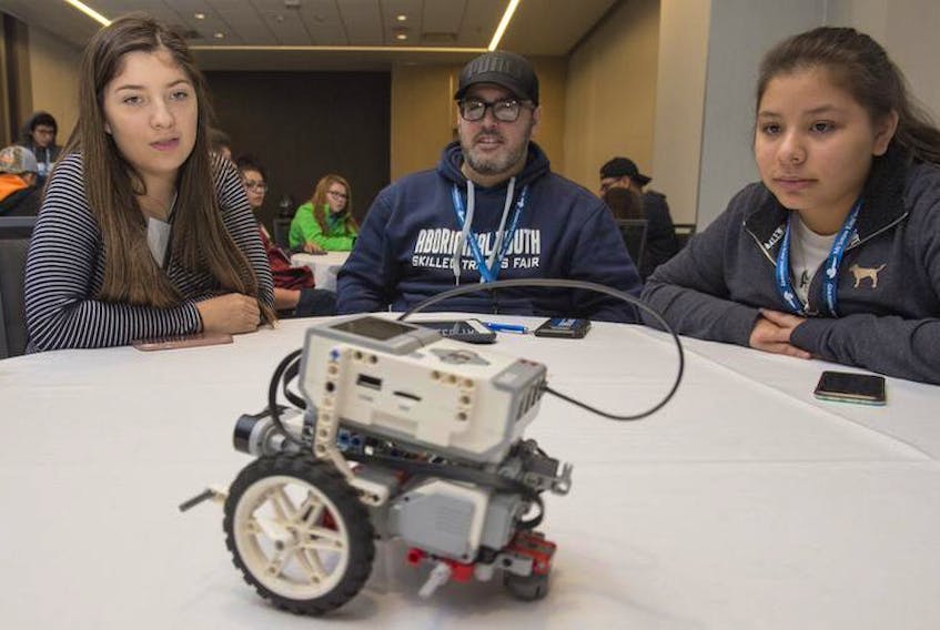 Eskasoni’s Neve Stevens (left) and Cheyenne Paul use an iPad to control a LEGO EV3 robot with chaperone Josh Nichols during a robotics workshop for the Aboriginal Youth Skilled Trades Fair at the Halifax Convention Centre on Tuesday.