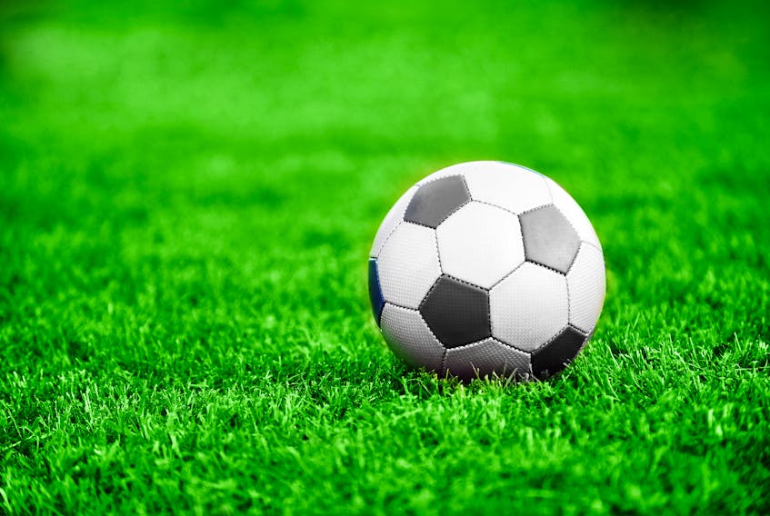 A soccer ball sits on a pitch.