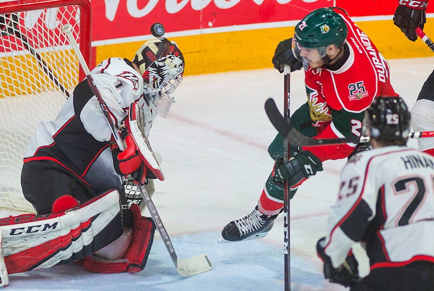 Rouyn-Noranda Huskies goalie Samuel Harvey and Halifax Mooseheads forward Arnaud Durandeau look for the puck during Saturday's QMJHL playoff game at the Scotiabank Centre.