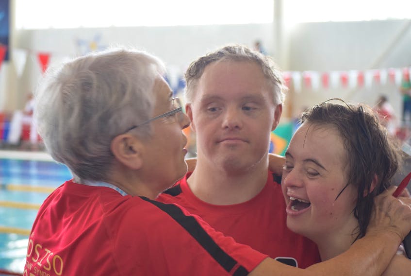 While Australia is surging ahead in the points and medal counts, Team Canada is still putting up a good fight in the Down Syndrome World Swimming Championships at Truro’s Rath Eastlink Community Centre. From left: Coach Sallie Szanik embraces Team Canada swimmers Ryan Roznowski and Abby Wilson in between swimming races on Wednesday morning.