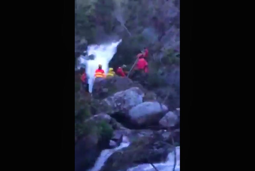 A still image from a video shared by the Spaniard's Bay Volunteer Fire Department shows rescuers lifting an injured boy to a helicopter awaiting his arrival from above. CONTRIBUTED STILL IMAGE