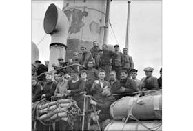 The men on this merchant ship survived a torpedoe attack during the Second World War. This was the scene as they docked in St. John's, September 1942. — Gerald Milne Moses/ Library and Archives Canada