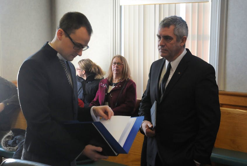 Lawyer Kyle Rees chats with Frank Butt prior to courtroom proceedings in St. John's Wednesday morning. Rees appeared as an agent for Butt's lawyer, John Babb.