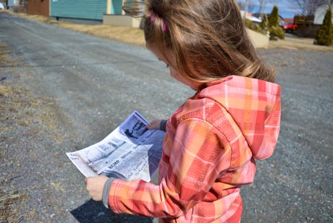 Sophie Cranford, age six, reads an article about the shooting printed by The Daily News in 1964. She is standing in the exact spot where Const. Robert Amey died.