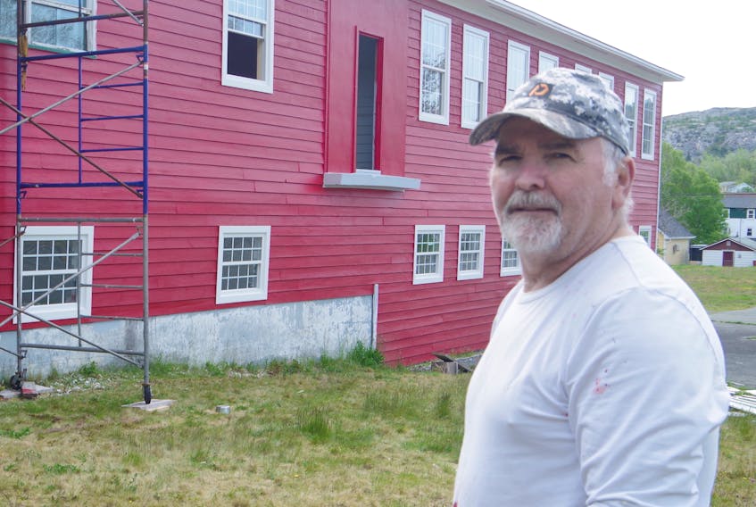 Jim Power is nearly finished adding a bright red coat of paint to the old school in Brigus.