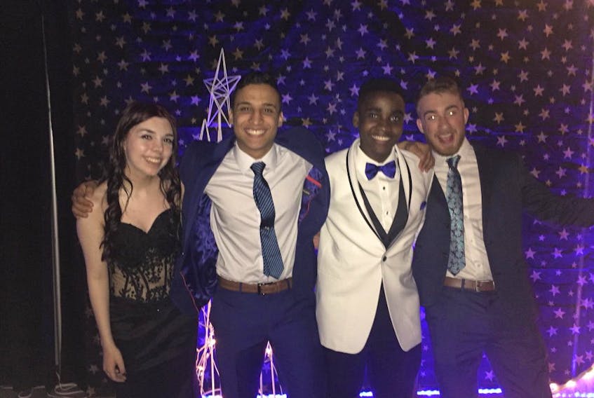 Essam Azaghdani, second from the left, poses for a photo at his high school graduation alongside friends (from the left) Katie Butt, Emmanuel Gonese and Jack Green.