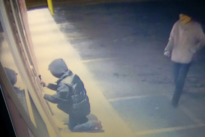 An image captured by a security camera of two suspects breaking into a business in Conception Bay North.