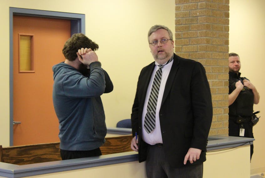 Roberts (left) conversing with his lawyer prior to his bail hearing.