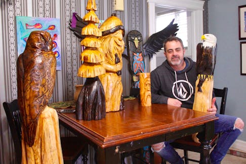 Shawn Rowe, surrounded by some of the carvings he’s completed.