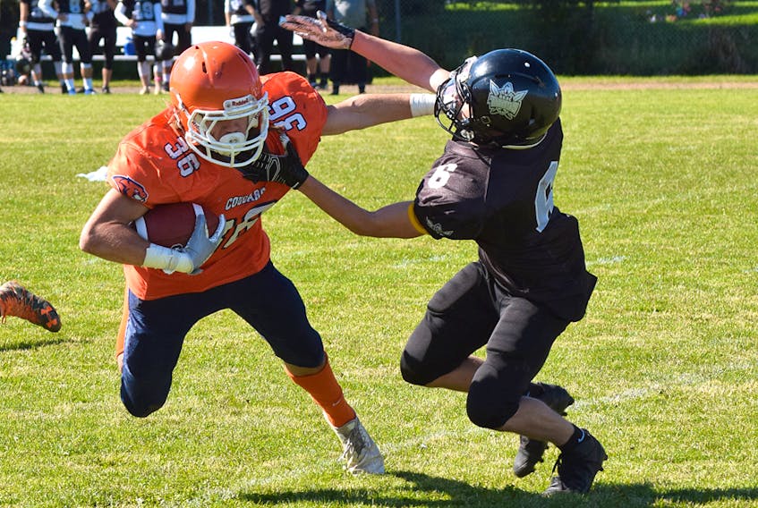 Cobequid Cougars running back Andrew Floyd straight arms a defender during NSSAF football action last week in Truro. Floyd ran for almost 100 yards and scored a touchdown as the Cougars earned a 21-6 victory over the Northeast Kings Titans. Truro News