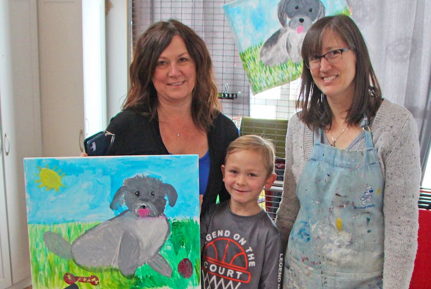Seven-year-old Adam Geldart, with some help from his motherAndrea Doucette, left, and instructor Andrea ‘Andy’ Pumphrey, proudly displays his creation from a Jan. 18 paint party at The Arts House in Antigonish. Corey LeBlanc