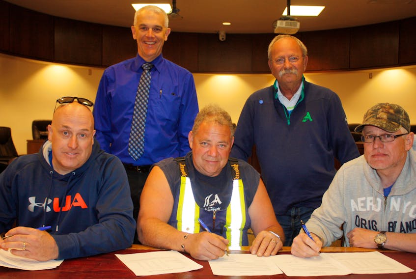 Amherst CAO Greg Herrett and Mayor David Kogon watch as CUPE Local 1233 president Matt Gould, shop steward Vaughn Martin and treasurer Paul Hawkes sign a one-year extension of their contract with the town. - Town of Amherst photo