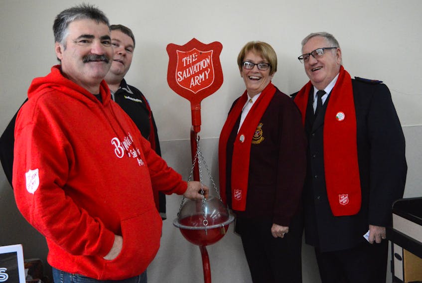 Left to right are local resident Kevin Hynes, placing a donation into the kettle; Independent store owner Darrel Cross; and corps officers Audrey Thompson and Sgt. Maj. Dave Thompson. The kettle campaign runs up to Dec. 20.