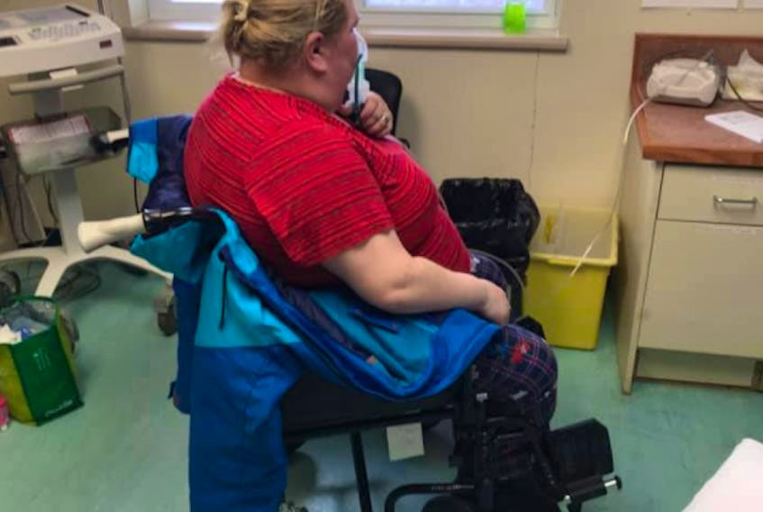 Stephanie Holmes sits in the minor procedure room at the Fogo Island Health Centre as she deals with severe pain from multiple tumours in her lungs. Her husband, Ryan Holmes, says they were refused entry into acute care due to all the beds being taken up by long-term care patients, and were directed to travel to Gander for further treatment.